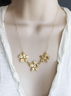 "Three little gold plated lily flowers dancing in a line topped with a fresh water pearl. Photo shows the flowers on a 18\" 14 KT gold fill chain. Spring clasp closure Matching earrings : https://www.etsy.com/listing/75898763/gold-flower-earrings-white-coin-pearl?ref=shop_home_active_22 Photoed with a 16\" chain on model H A N D M A D E * We hand make all pieces in our Water Mill New York studio * We source eco friendly packaging and materials, including recyclable mailers! FREE BOX AND WRAP ON Elegant Gold Flower Necklace For Wedding, Gold Necklaces With Flower Decoration For Wedding, Gold Necklace With Flower Decoration For Wedding, Yellow Gold Flower Charm Necklace For Wedding, Yellow Gold Flower Necklace With Charm For Wedding, Yellow Gold Flower Necklace For Wedding, Gold Flower Charm Necklace For Wedding, Gold Pearl Flower Necklace For Gift, Wedding Flower Necklace With Flower Charm