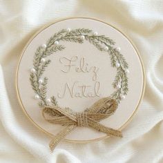 a white embroidered wreath with the words holly natl on it