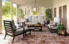 a living room filled with furniture on top of a brick floor next to a patio