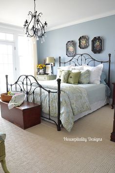 a bed room with a neatly made bed and a chandelier