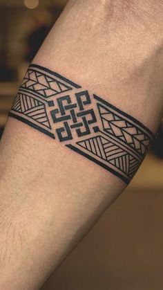 a man's arm with a tattoo on the wrist and an intricate design in black ink