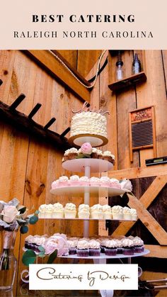 a table topped with lots of cupcakes next to a wooden wall covered in signs