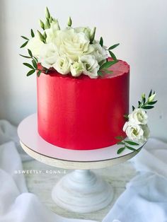 a red cake with white flowers on top