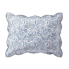 a blue and white pillow with an intricate design on the front, sitting on a white surface