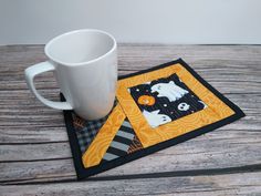 a coffee cup sitting on top of a wooden table next to a mug cozyie