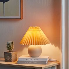 a lamp sitting on top of a table next to a book