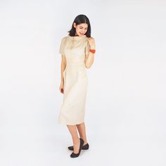 "This 1950s day dress is a classic sheath in cut. It is made of unlined rayon butcher cloth, very much like linen in look and feel, and in a linen-like natural color. There is a wide stand-up collar with picot trim and burnt orange accent fabric. A small self-fabric bow embellishes the center front. There are angled front pockets, a back kick pleat and a side covered metal zipper. There is no label in the dress, but it definitely appears commercially made. CONDITION: Just back from my eco-friend Fitted Linen Dress With Short Sleeves For Work, Fitted Short Sleeve Linen Dress For Work, Classic Beige Linen Midi Dress, Cream Linen Fitted Midi Dress, Fitted Cream Linen Midi Dress, Classic Knee-length Linen Dress For Workwear, Fitted Beige Linen Dress For Work, Fitted Cream Linen Dress, Classic Fitted Linen Dress For Work