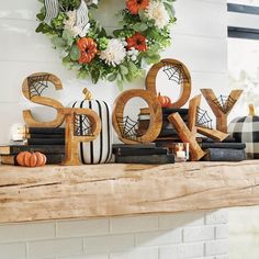 a fireplace mantel decorated for halloween with pumpkins, books and spider web decorations