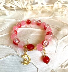 Beautiful blends pink and red cracked marbled beads with little cute gold colored rabbit charm. 100% hand made and good gift for friends or family. Cute Red Bracelets As Gift, Cute Red Bracelets For Gift, Cute Red Bracelets For Gifts, Handmade Pink Gold Beaded Bracelets As Gift, Handmade Pink Gold Bracelets As Gift, Handmade Pink Gold Beaded Bracelet As Gift, Golden Moon, Rabbit Charm, Moon Cat