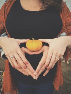 a woman holding a pumpkin in her hands