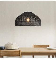 a wooden table and chairs with a light hanging from the ceiling