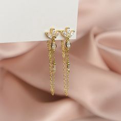 The pair you'll reach for again and again. Add a touch of sparkle to your life with these shimmering gems, designed to complete any look. Handcrafted with a sterling silver base, 14k gold plating and cubic zirconia, these earrings are truly one of a kind. Measuring 40mm in height, they are the perfect accessory to dress up any outfit. Whether you're heading to a party or just running errands, these earrings will add a touch of elegance to your day. Elegant Gold Plated Linear Earrings For Anniversary, Luxury Sterling Silver Linear Earrings For Party, Silver Diamond Earrings Gold Plated, Gold Cubic Zirconia Jewelry For Party, Luxury Cubic Zirconia Bridal Earrings For Pierced Ears, Elegant Gold Plated Long Drop Earrings, Elegant Gold Plated Chandelier Earrings, Evening Cubic Zirconia Bridal Earrings, Gold Cubic Zirconia Plug Earrings As Gift