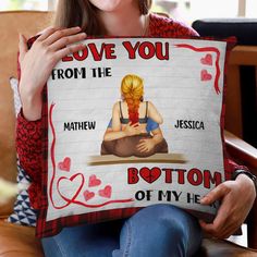 a woman is holding up a pillow that says i love you from the bottom