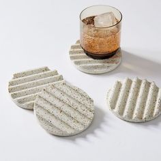 three coasters and a glass on a white surface