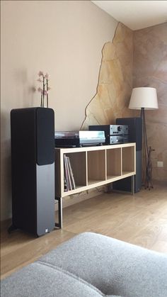 a living room with two speakers and a couch