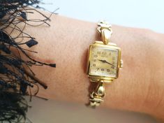 Vintage art deco 1940s ASTIN ROLLED GOLD ladie's cocktail watch  ROLLED GOLD WATCH SWISS MADE Power: mechanical / wind up Readout: Analogue Style: ART DECO Description Dainty gold plated 1930s / 1940 art deco rolled gold (1/10) cocktail watch. A rare and feminine vintage watch for a unique gift. Beautiful vintage watch with a raised dome crystal to make the pale champagne  gold watch face really stand out. Beautiful square afce with black dials and gold numerical index markers on each hour. Swis Art Deco Gold Watches For Evening, Gold Art Deco Evening Watch, Gold Adjustable Evening Watch, Adjustable Gold Watches For Evening, Adjustable Gold Evening Watch, Gold Art Deco Watch For Anniversary, Gold Art Deco Anniversary Watch, Gold Art Deco Wedding Watch, Dainty Watch