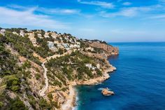 an aerial view of the ocean and coastline with houses perched on top of cliffs