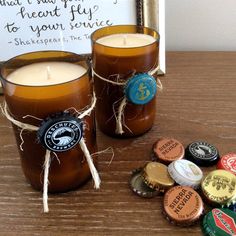 two candles are sitting next to some bottle caps