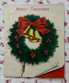 an old fashioned christmas card with a bell and holly wreath on it's front