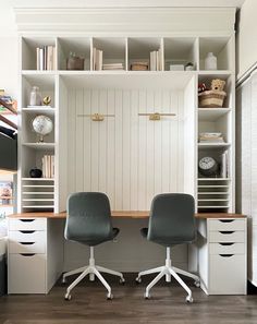 two office chairs sitting in front of a desk with bookshelves and shelves behind them