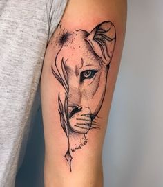 a black and white tattoo of a lion's face on the left upper arm