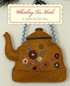 a felt teapot ornament hanging from a christmas tree with the words wishing tea kettle to make the call grey