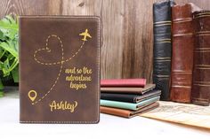 a passport case sitting on top of a table next to some books and an air plane