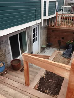 an outdoor patio with steps leading up to the back door and stairs going up to the second floor