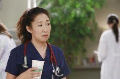 a woman in scrubs holding a coffee cup