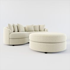 a white couch and ottoman sitting next to each other on top of a gray floor