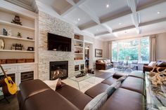 a living room filled with furniture and a fire place in front of a tv mounted on a wall