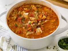 a white bowl filled with soup next to a spoon