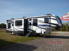 an rv is parked in front of a sign