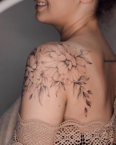 a woman with a flower tattoo on her shoulder