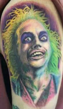 a man's arm with a portrait of the joker and his name on it