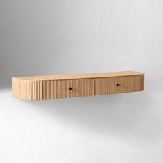 a wooden shelf sitting on top of a white wall