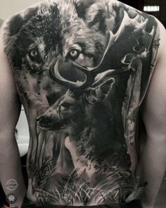 the back of a man's body is covered in tattoos with animals on it