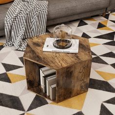 a small wooden table sitting on top of a black and white checkered floor next to a couch