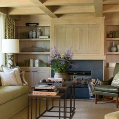 a living room filled with furniture and a fire place in the middle of a room