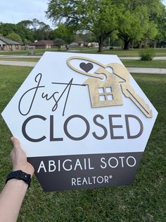 someone holding up a sign that says just closed abigal soto realtor