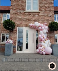 a large balloon arch in front of a brick building