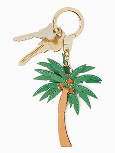 a key chain with a palm tree on it and two keys hanging from the front