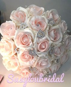 a bridal bouquet made up of pink roses and diable brooches with crystals