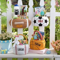 a white picket fence with baskets and sports items on it, along with other decorations