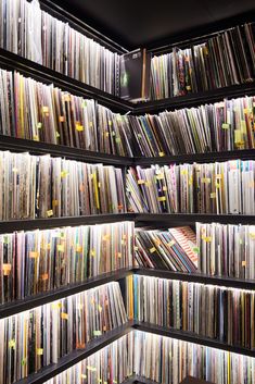 a room filled with lots of different types of records on shelves next to each other