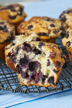 blueberry muffins on a cooling rack with one cut in half to show the inside