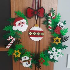 a christmas wreath made out of plastic beads with santa and snowman decorations on it