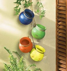 four pots are hanging on the wall