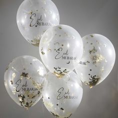 five clear balloons with gold stars and moon confetti