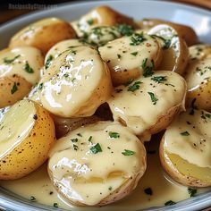 potatoes covered in gravy and garnished with parsley on a plate